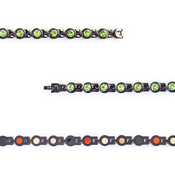 Close-up view showing green crystals and polished black interlocking links.